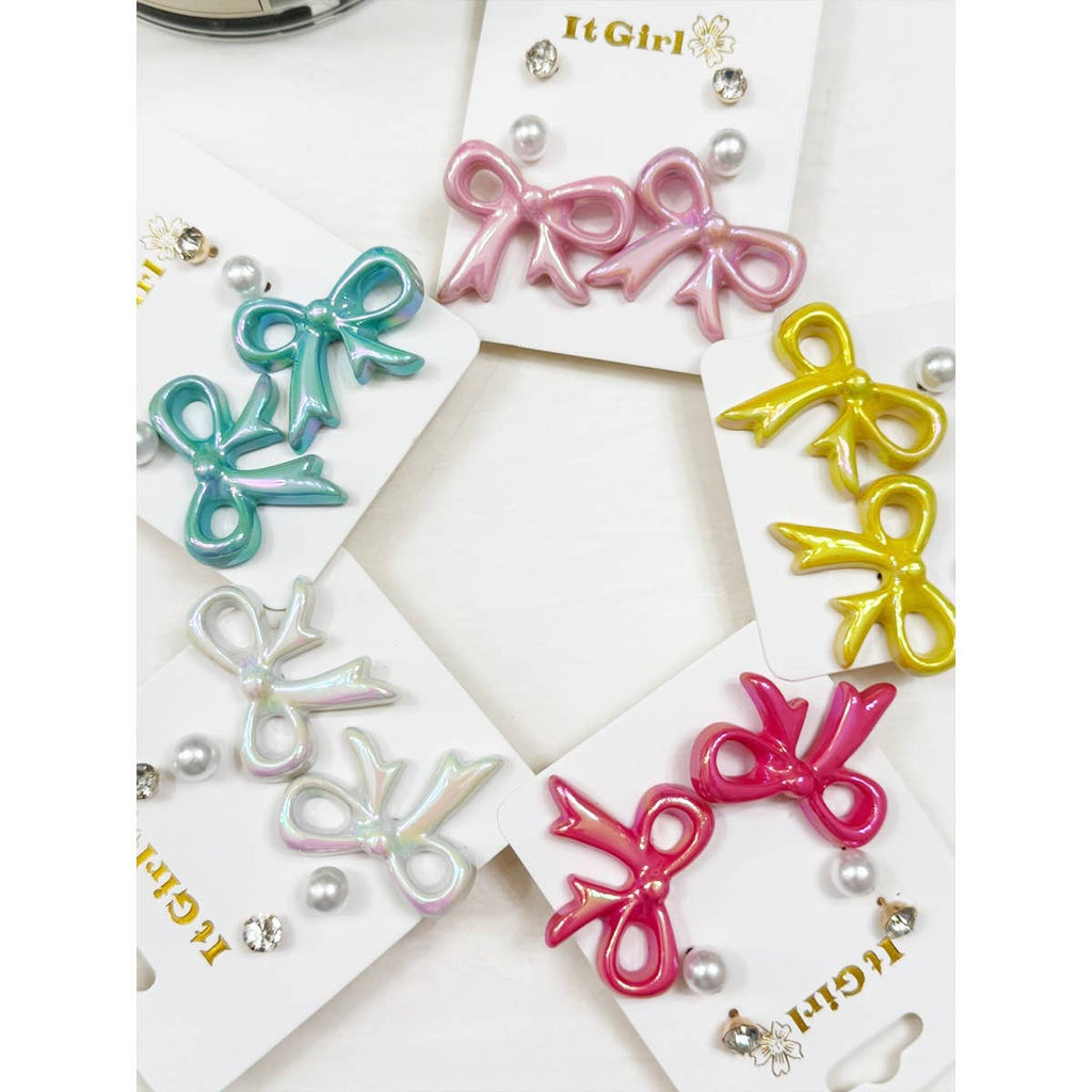 Colorful bow-shaped hair accessories on a white background with 'It Girl' branding.