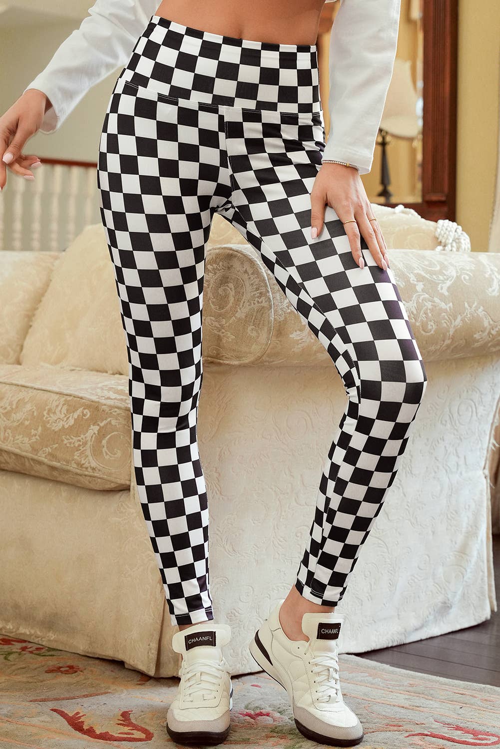 Person wearing black and white checkered leggings with a blurred indoor background