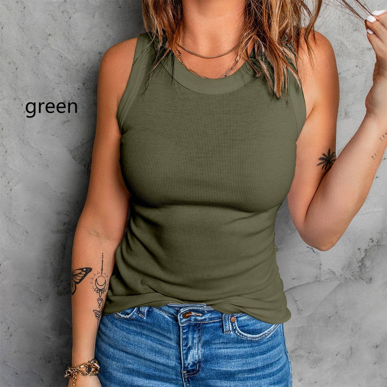Person wearing a green tank top against a gray concrete wall