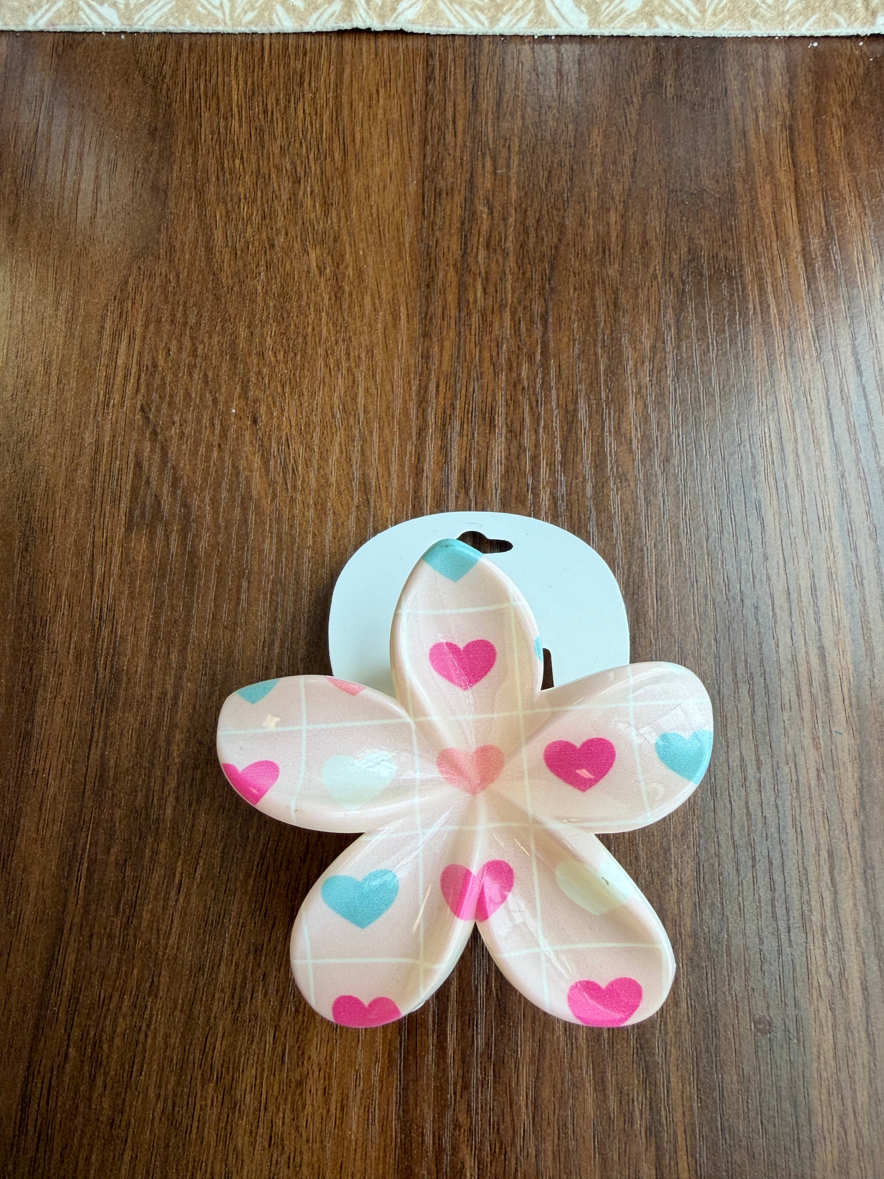 Flower-shaped object with heart patterns on a wooden surface