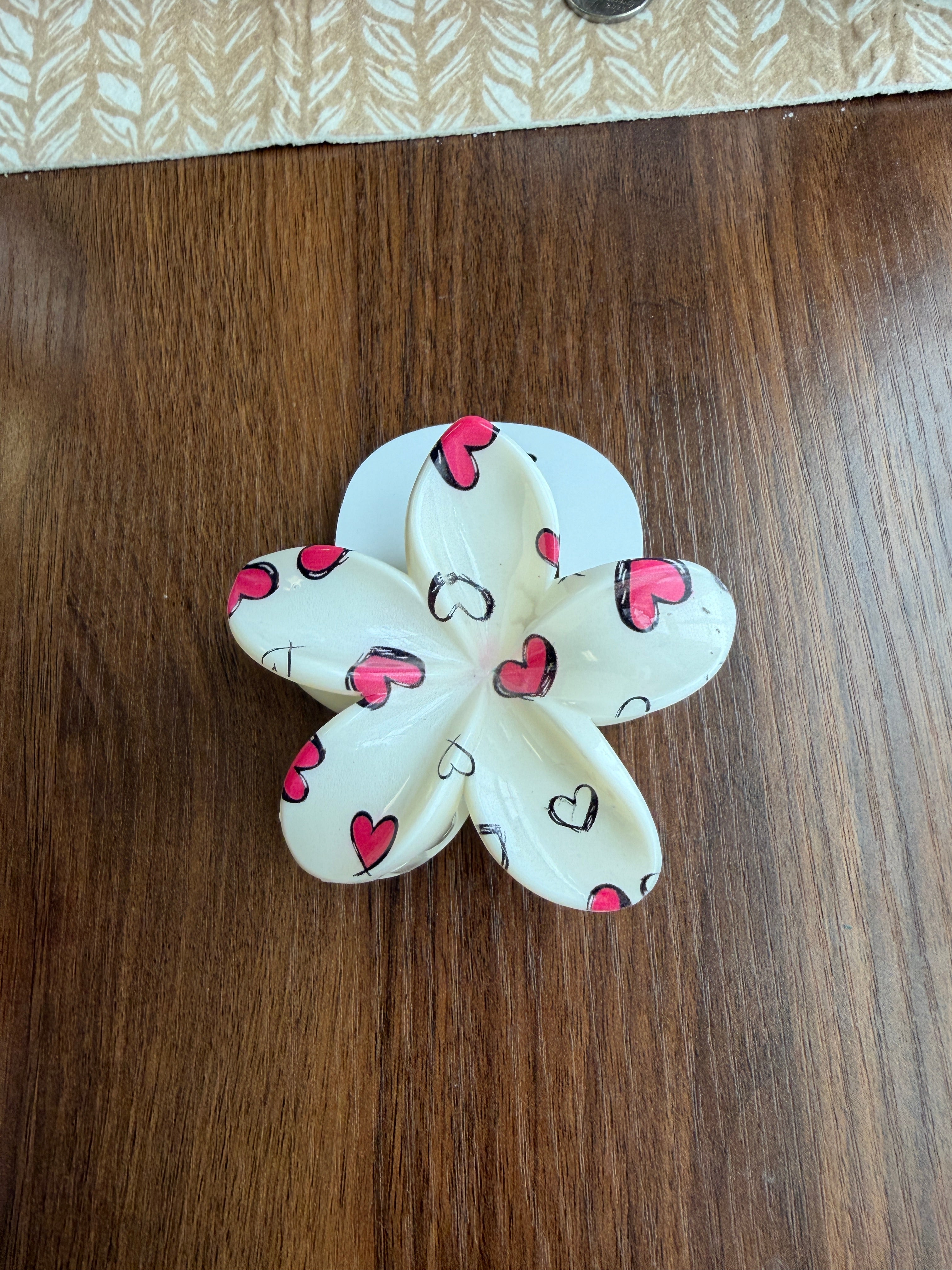 Flower-shaped object with heart patterns on a wooden surface