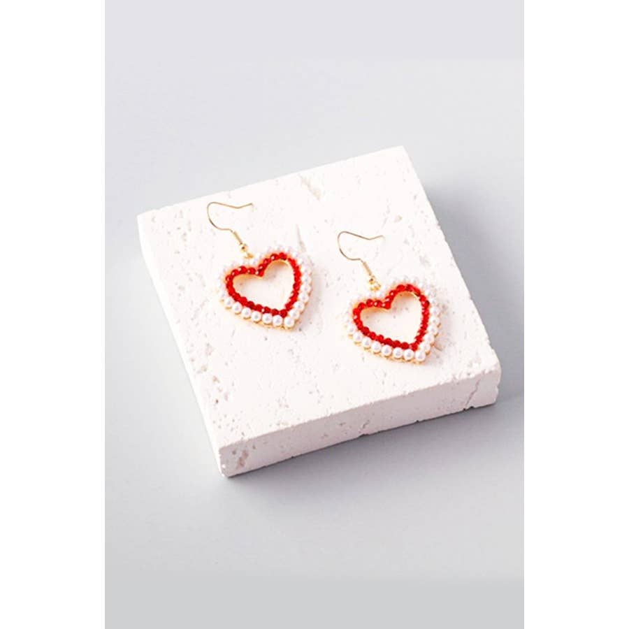 Heart-shaped earrings on a white display stand with a light gray background