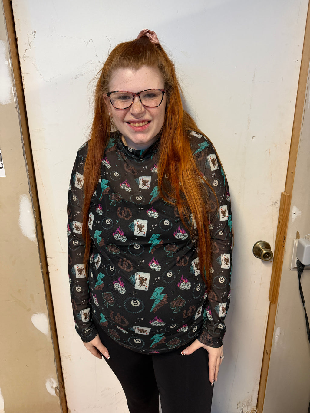Person wearing a patterned sweater sitting on a white surface.