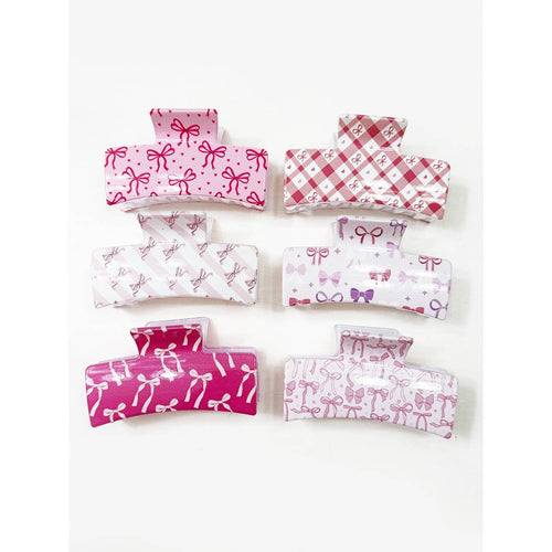 Set of pink and white hair accessories with bow patterns on a white background