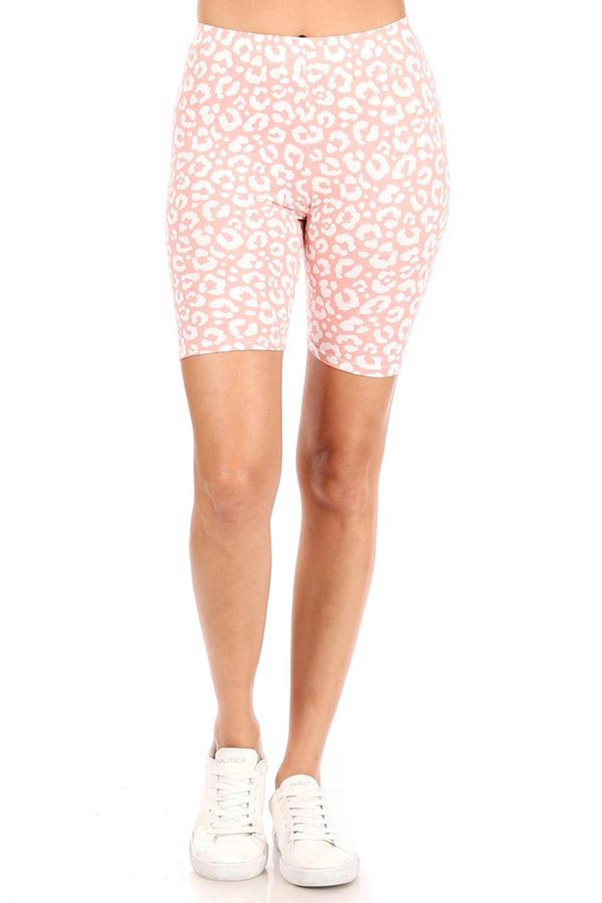 Person wearing pink shorts with white floral pattern on a white background